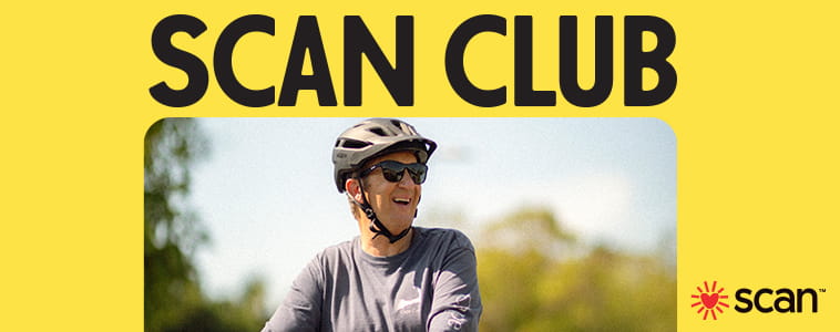 Senior wearing a helmet and sunglasses rides a bicycle outdoors.