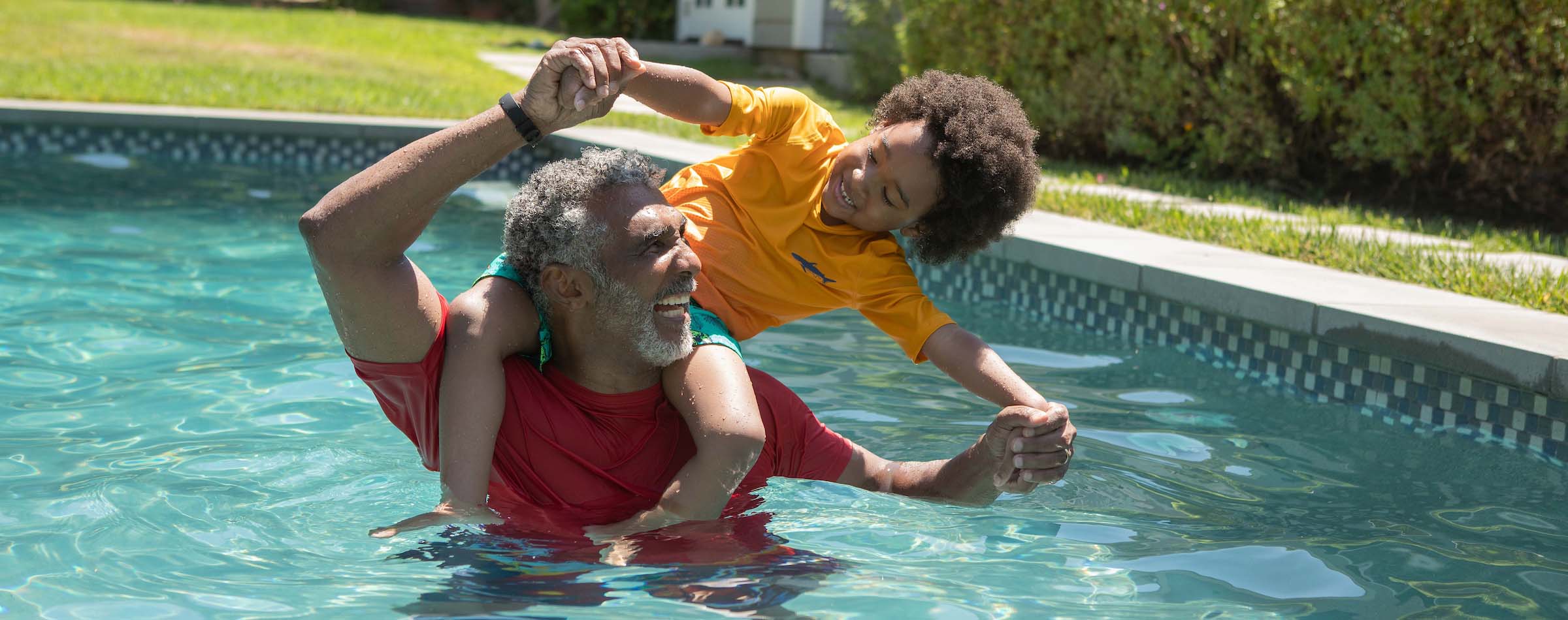 senior playing with child in pool